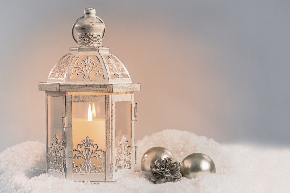 a white lantern sitting on top of a pile of snow