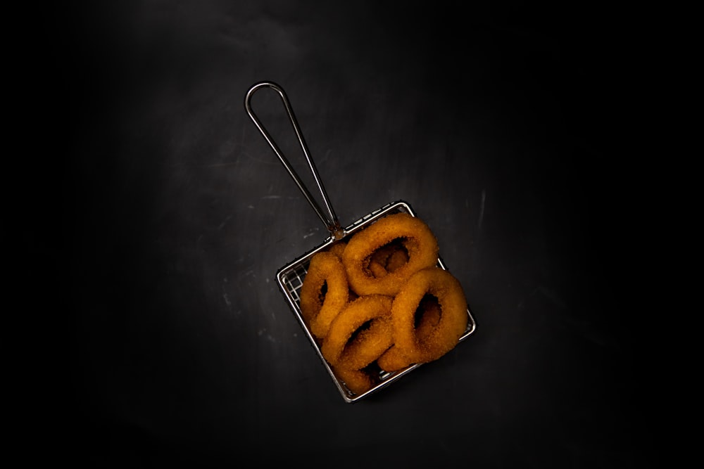 a square metal container filled with onion rings