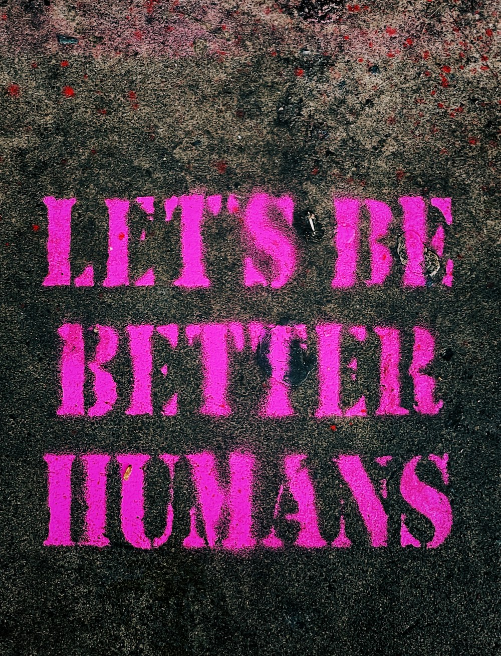 the words let's be better humans are painted on the sidewalk