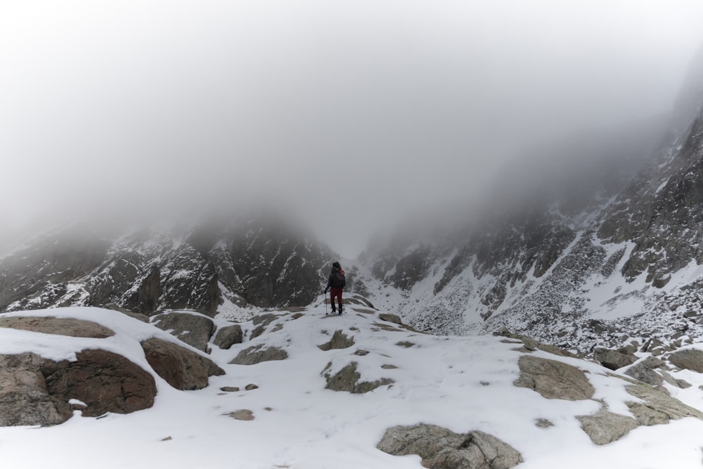 a man standing on top of a snow covered mountain