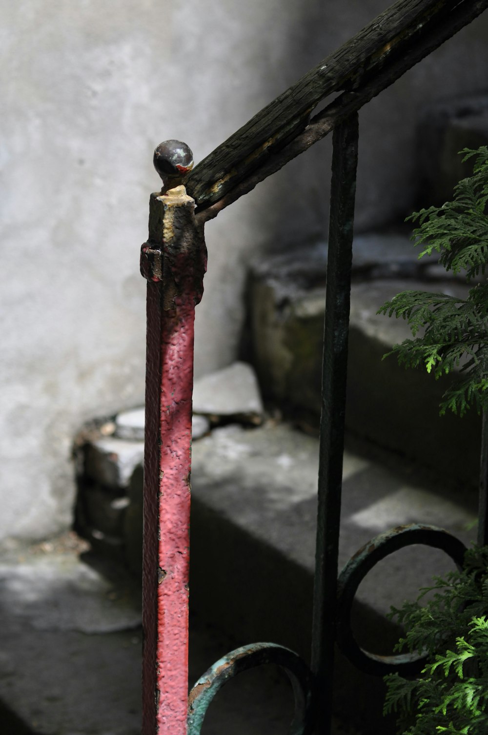 a rusted metal hand rail with a red handle
