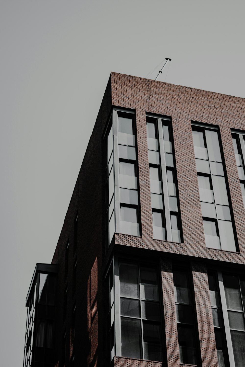 a tall brick building with a weather vane on top of it