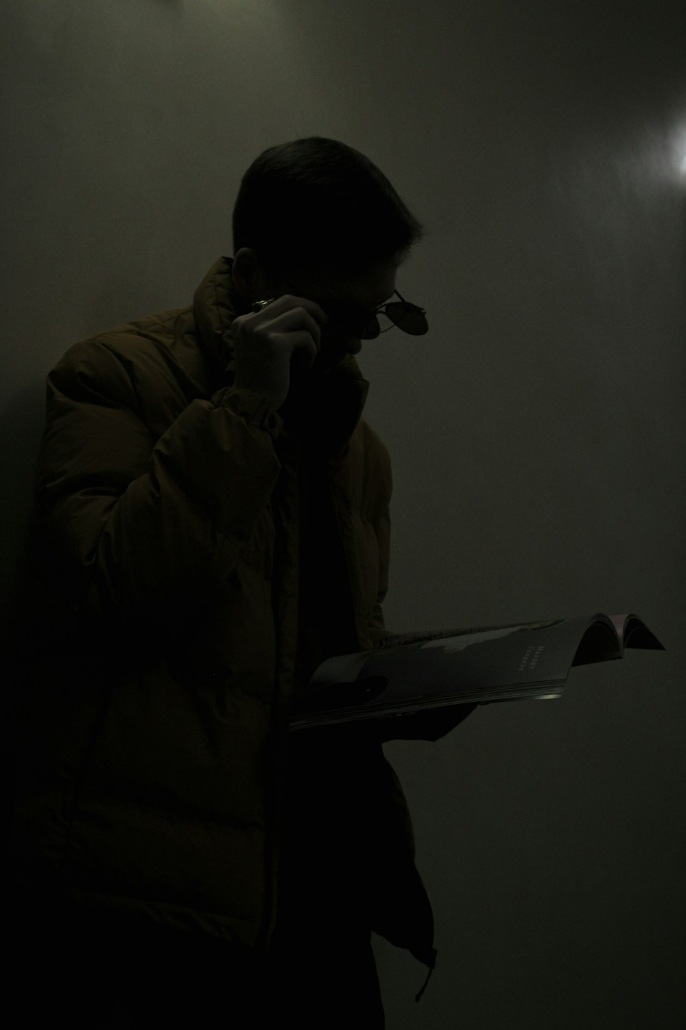 a man in a dark room talking on a cell phone