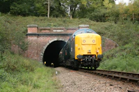 a train coming out of a tunnel on the tracks