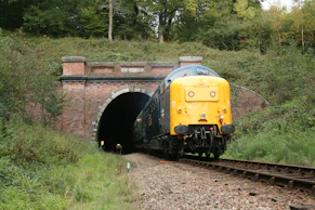 a train coming out of a tunnel on the tracks