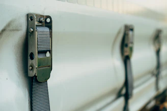 a close up of a metal latch on a white truck