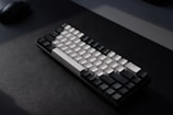 Close-up of a minimalist mechanical keyboard with soft backlighting on a dark desk.