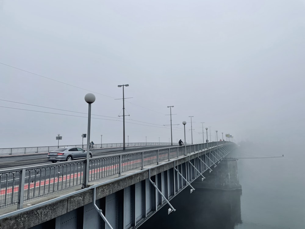 a foggy bridge with cars driving on it