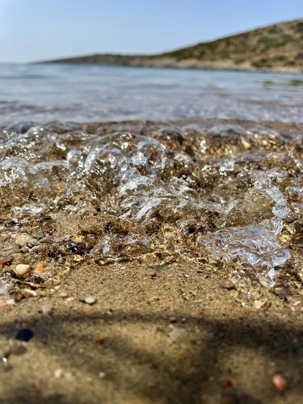 um close up de água e areia em uma praia
