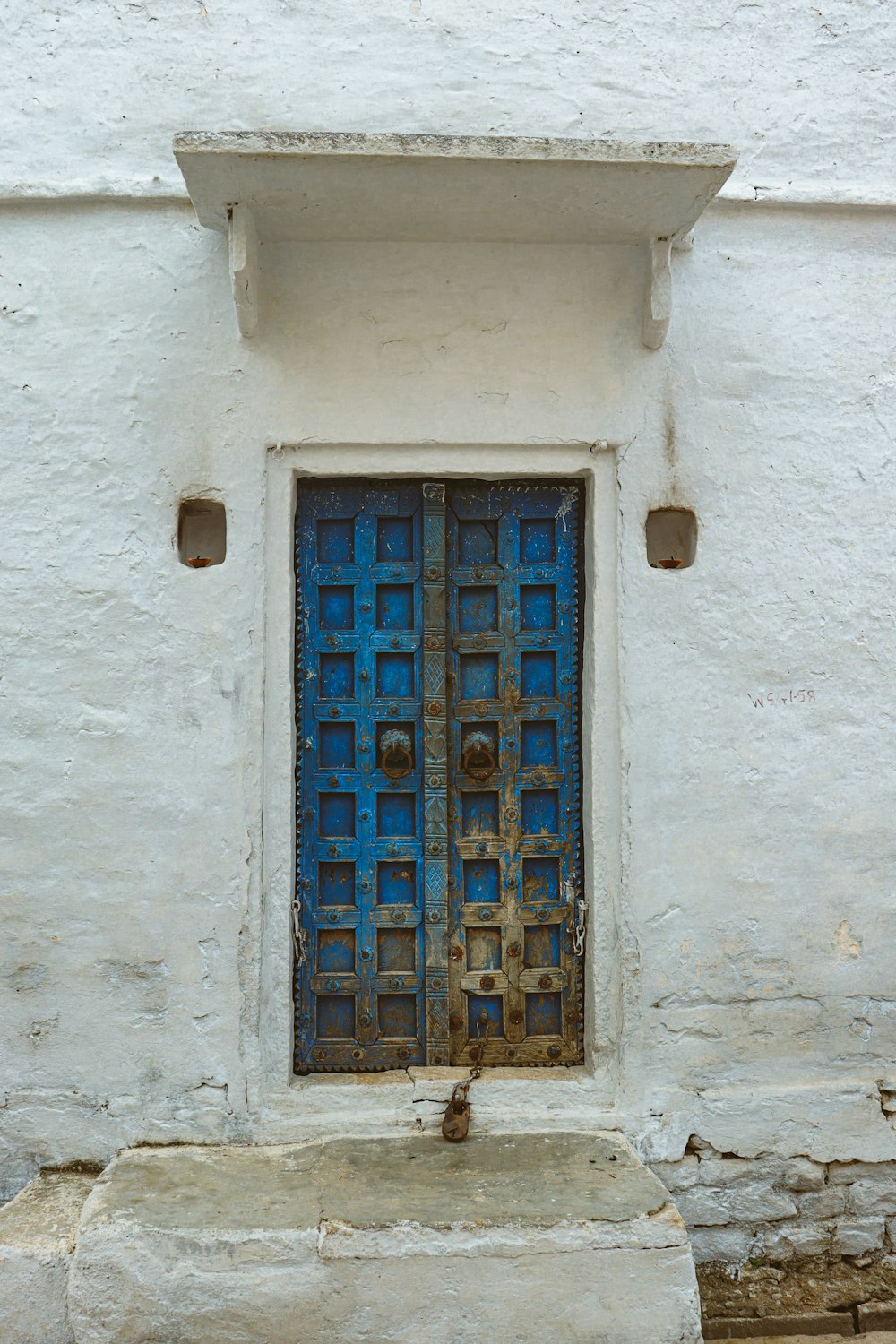 a white building with a blue door and window