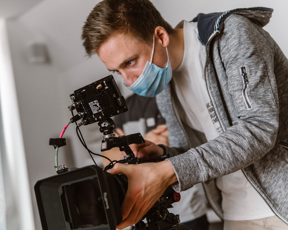 a man wearing a face mask and holding a camera