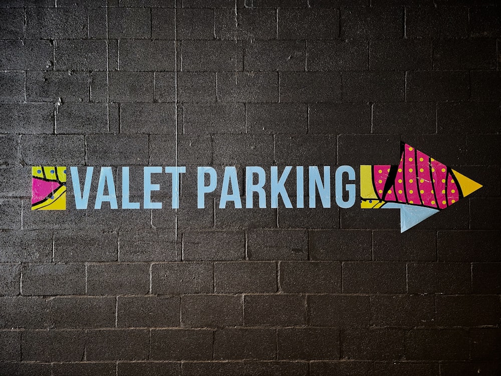 a painted sign on a brick wall that says valet parking