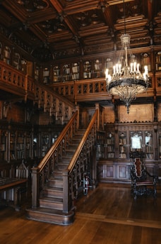 a chandelier hanging from a wooden ceiling in a library