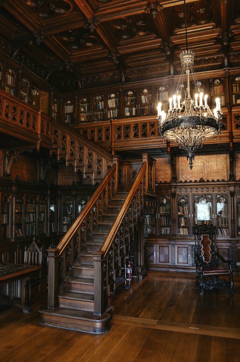 a chandelier hanging from a wooden ceiling in a library