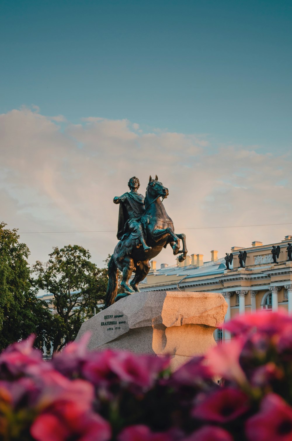 a statue of a man on a horse in front of a building