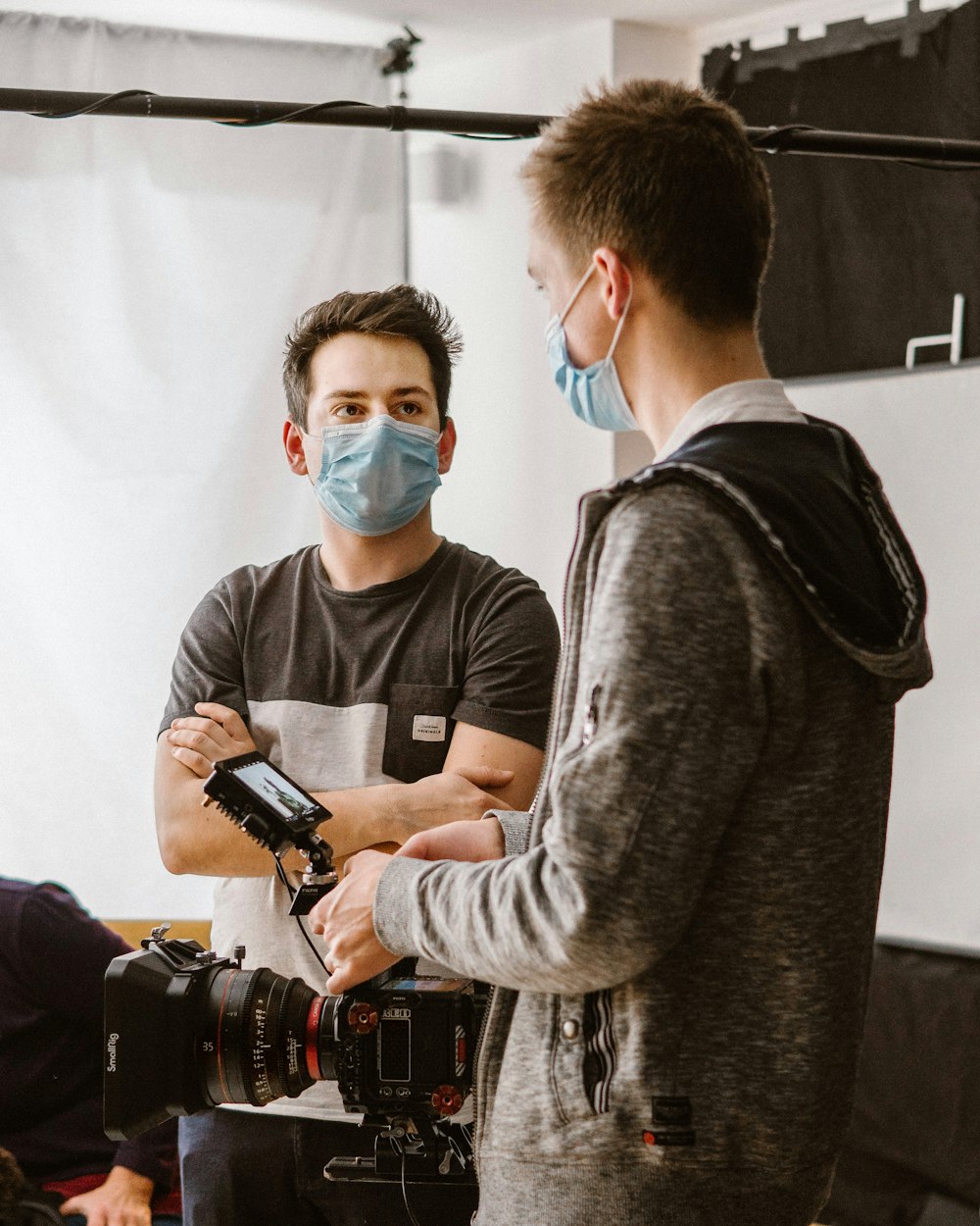 a man wearing a face mask standing in front of a camera