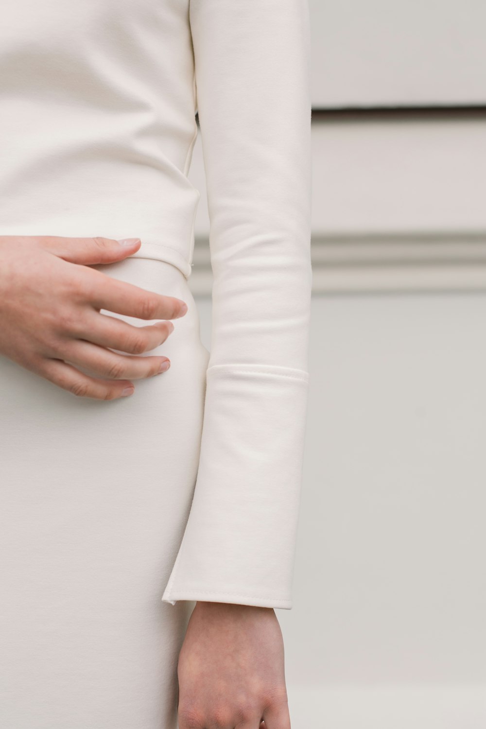 a woman in a white dress holding her stomach