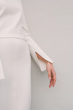 a woman in a white dress is holding her hand out