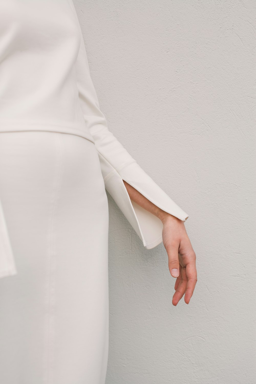 Una mujer con un vestido blanco está extendiendo su mano
