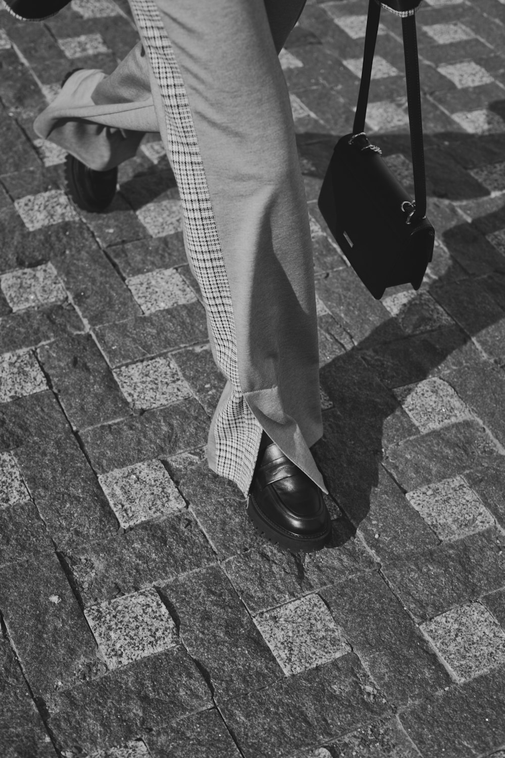 a person with a suit and tie walking on a sidewalk