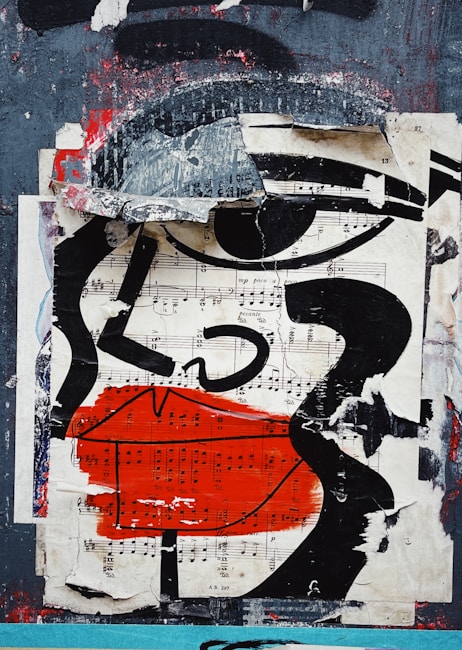 The artwork features a collage of torn and layered paper that includes sheet music and bold abstract shapes. Prominent black lines form the outline of a face with exaggerated features, such as large lips painted in vivid red. The background is a mix of distressed textures, blending gray, black, and hints of red, creating a sense of urban decay.