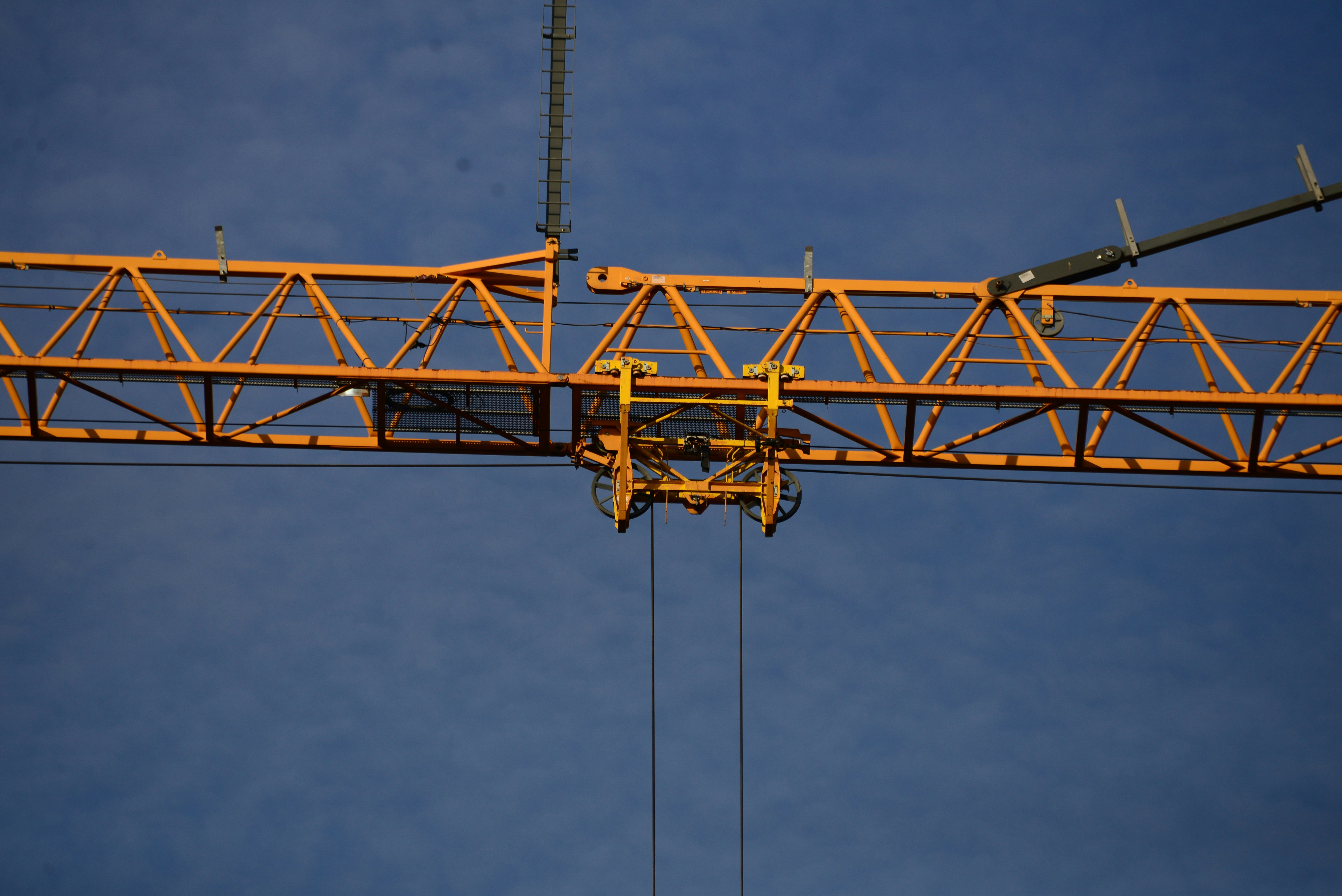 A yellow construction crane with a blue background