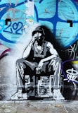 A graffiti artwork of a person wearing a hat and a large chain, sitting on a stereo or boombox. The background features colorful graffiti with patterns and numbers.