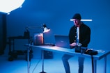 a man sitting at a desk using a laptop computer