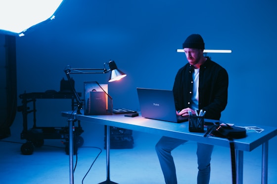 a man sitting at a desk using a laptop computer
