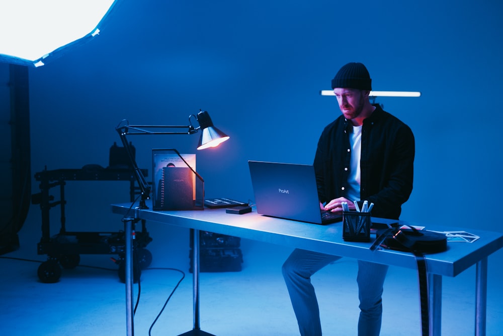 a man sitting at a desk using a laptop computer