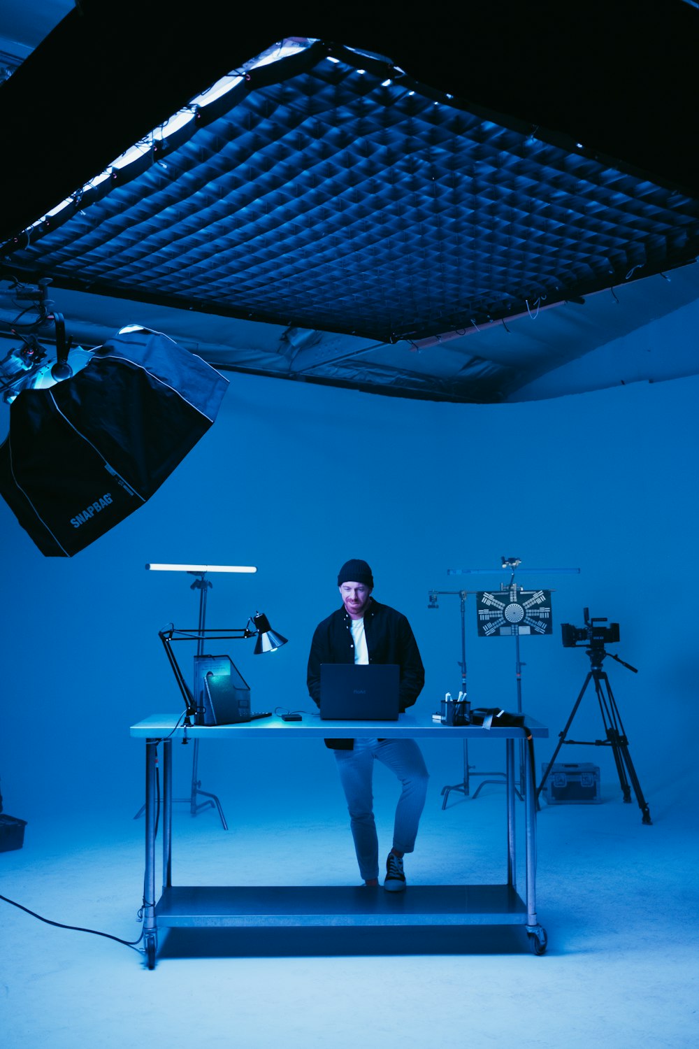 a man sitting at a desk in front of a camera