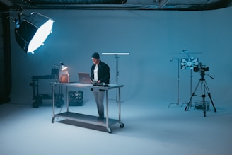 a man standing at a desk in front of a camera