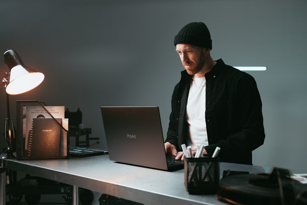 노트북 컴퓨터를 사용하여 책상에 앉아 있는 남자