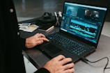 a man sitting at a table using a laptop computer