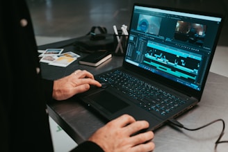 Video editor working on real estate footage using editing software on a laptop