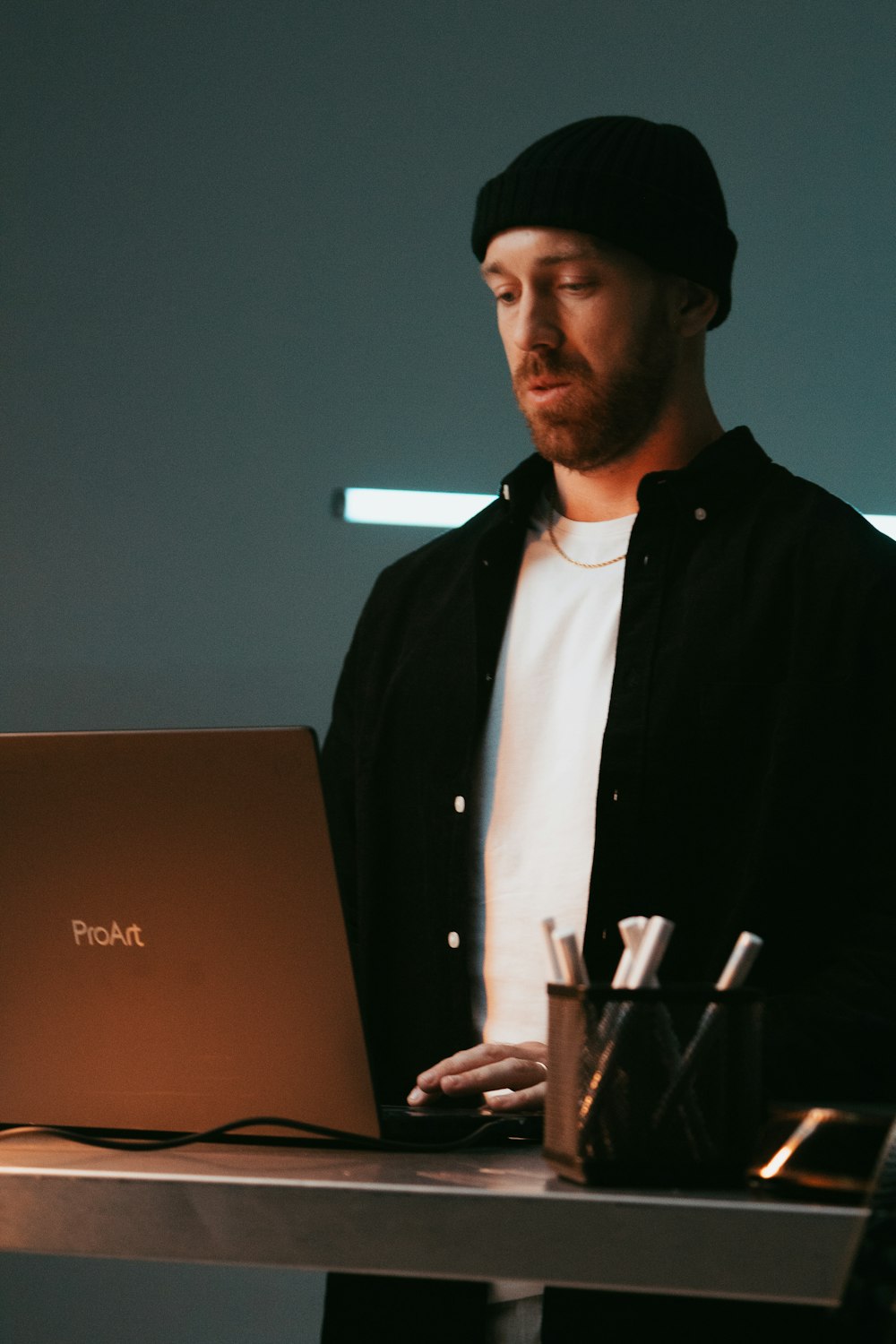 um homem em pé na frente de um computador portátil