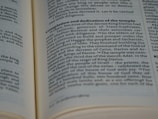 A close-up view of an open book with text in English. The page is focused on a section discussing the completion and dedication of a temple, referencing historical figures such as King Darius. The font is clear and the pages are cream-colored.