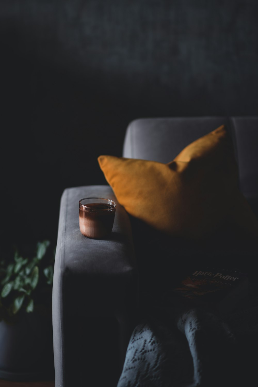 a cup of coffee sitting on top of a couch next to a pillow