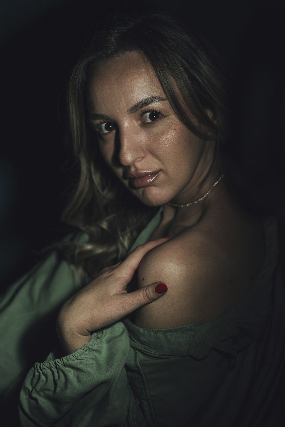 a woman in a green shirt posing for a picture