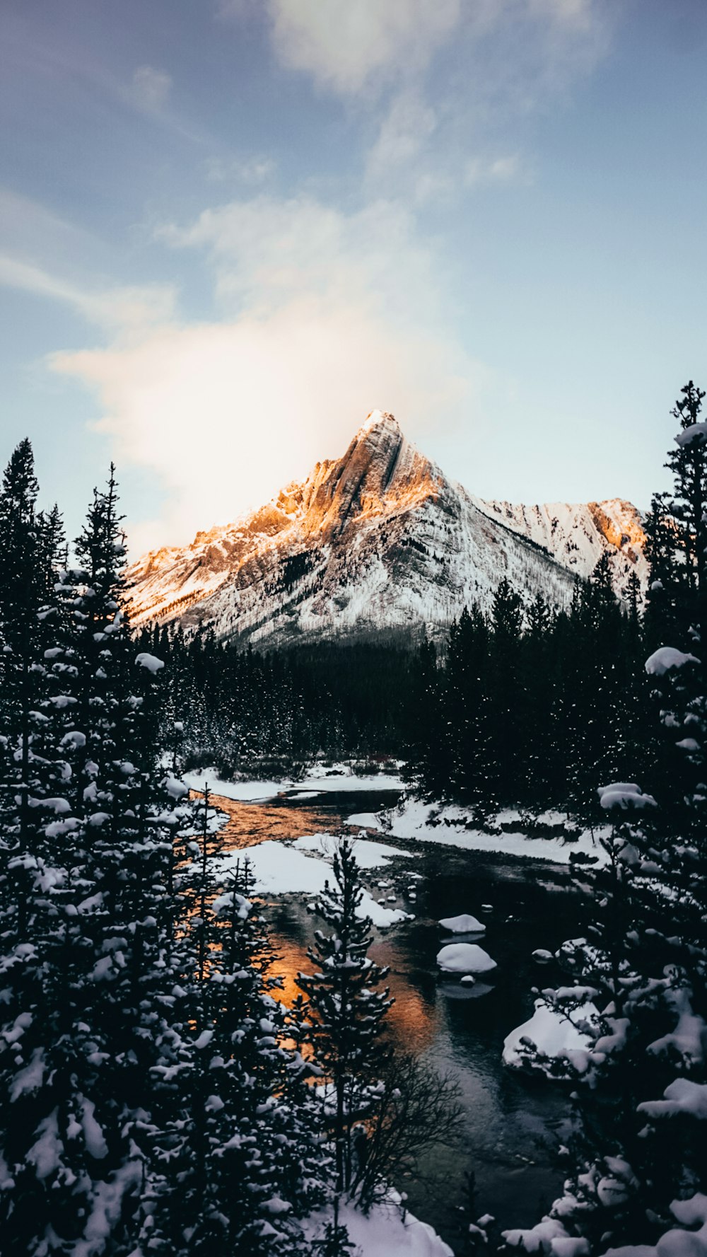 a snow covered mountain with a lake in the foreground