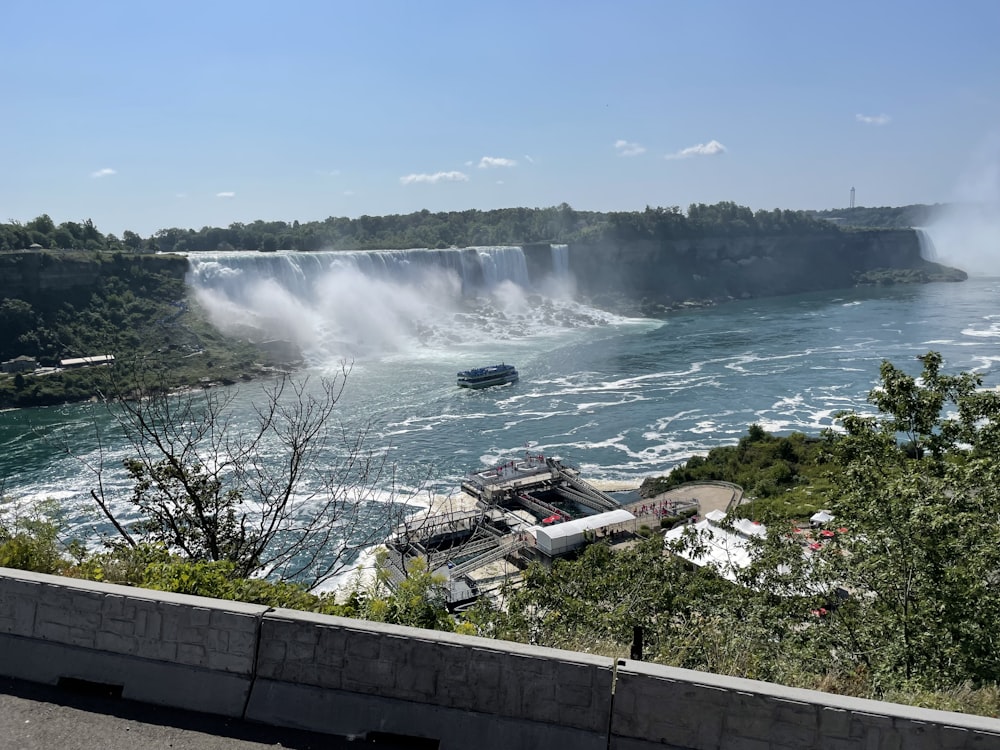 a boat is in the water near a waterfall