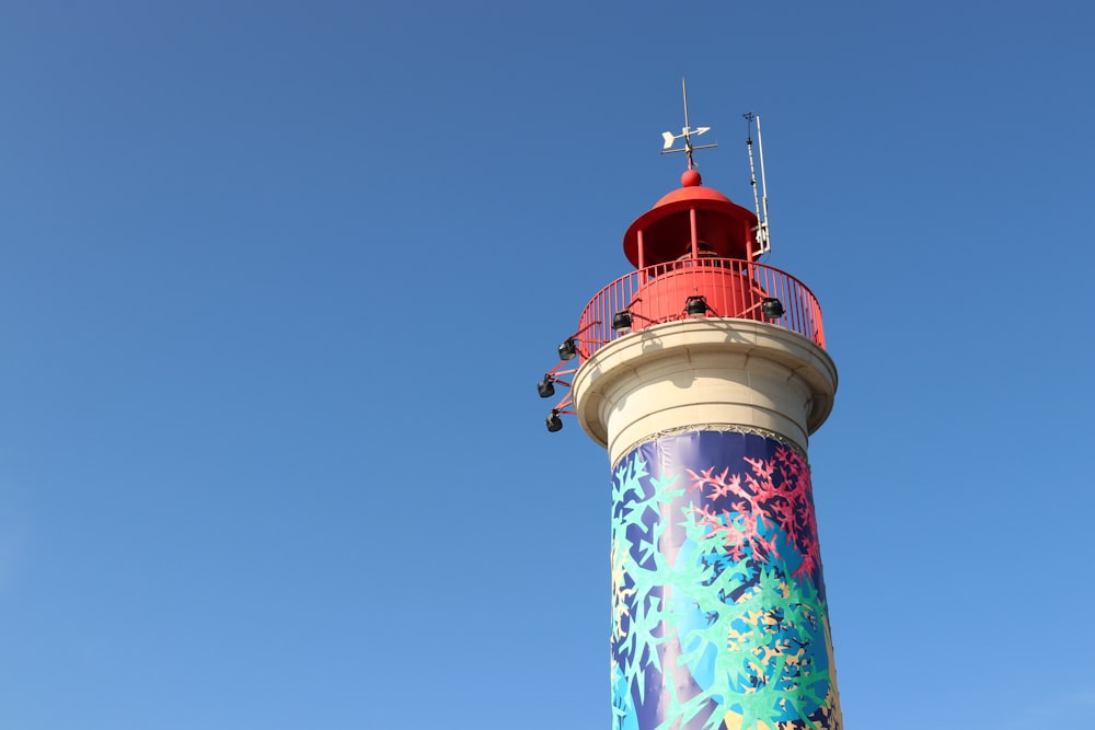 a red and white lighthouse with a blue sky in the background