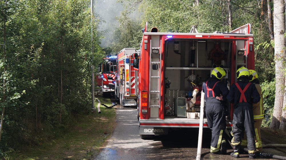 a group of fire fighters standing next to a fire truck