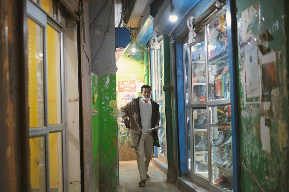 a man is walking down a narrow alley way