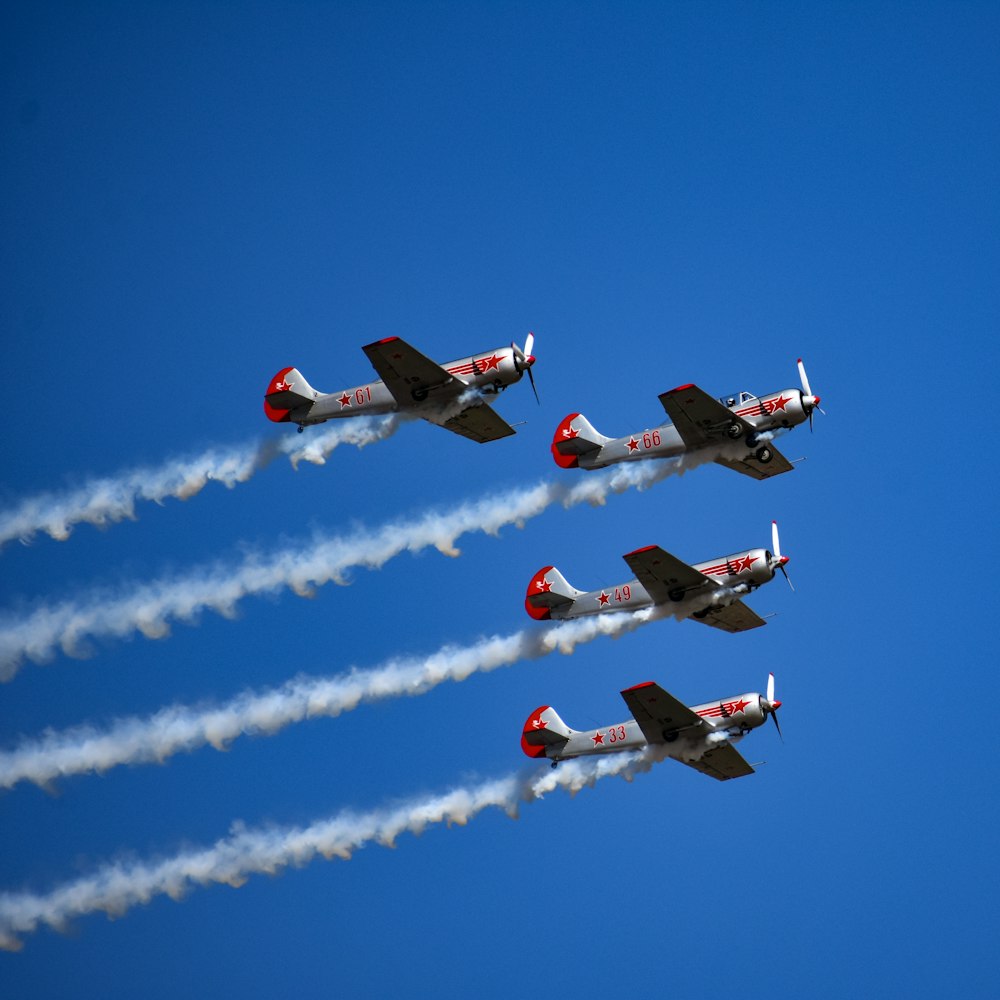 a group of airplanes flying through a blue sky