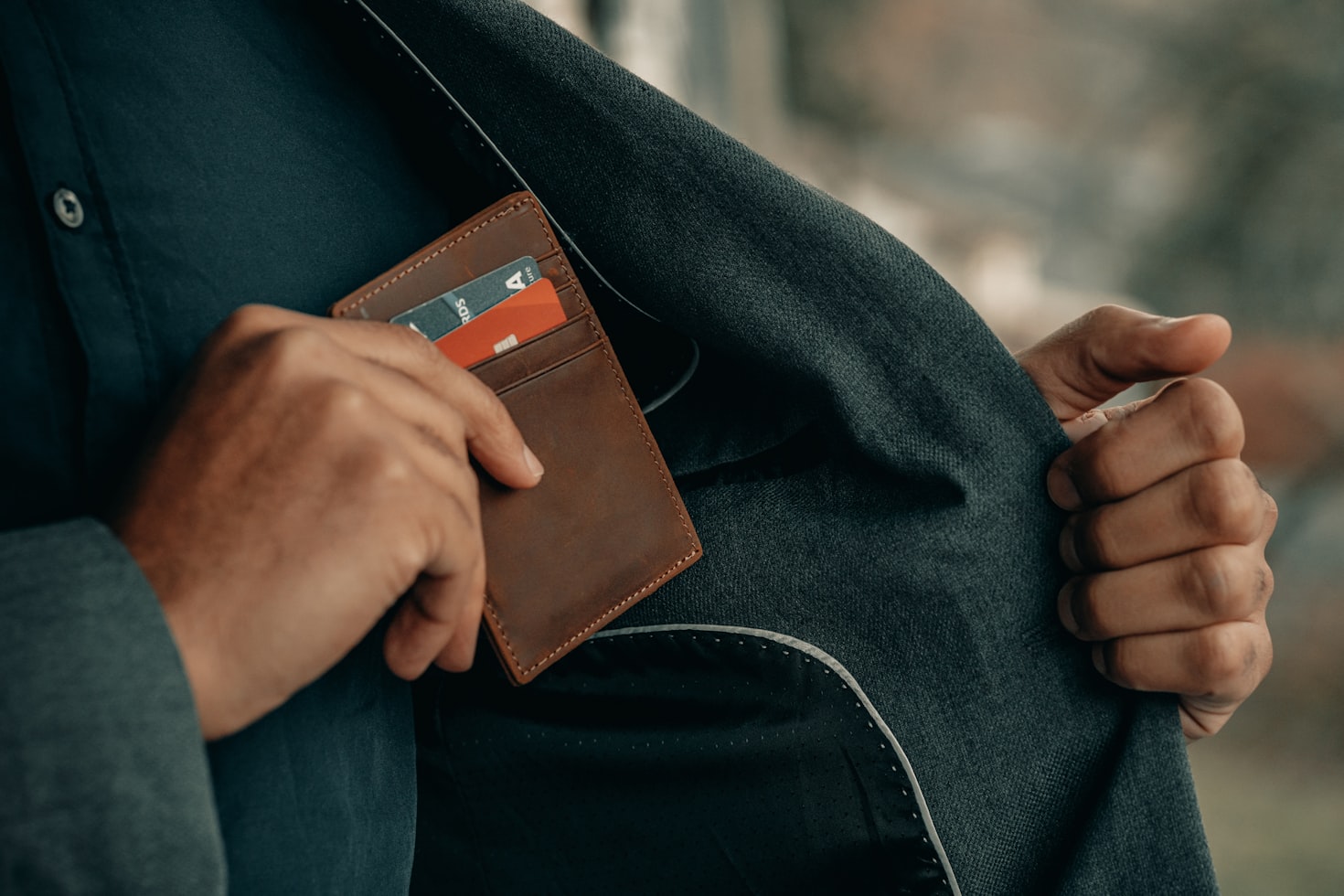 A person putting a card wallet in a pocket