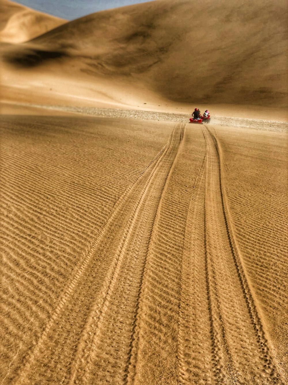 Ein paar Leute, die auf einer Sanddüne reiten