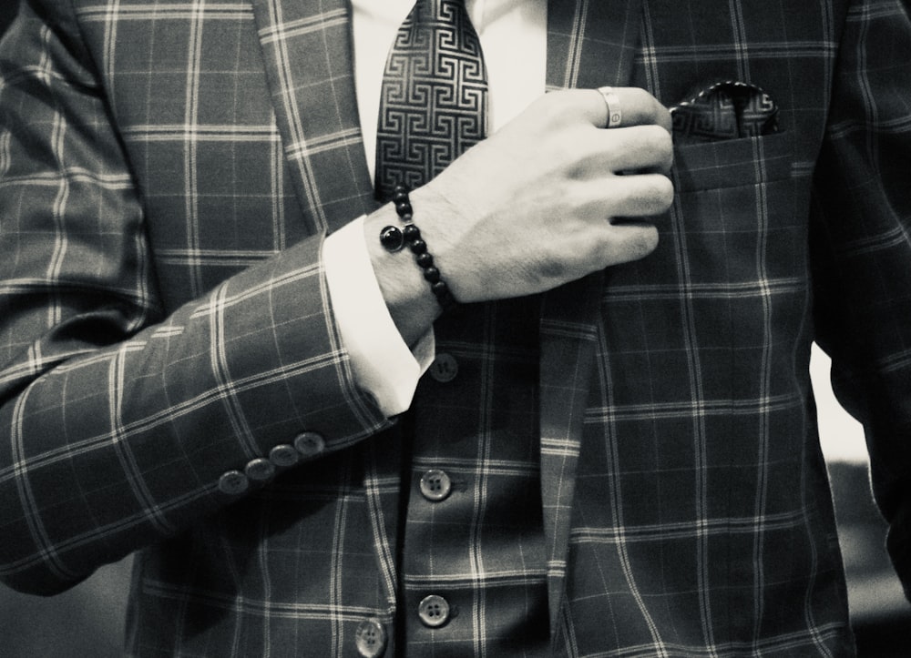 a man in a suit adjusting his tie