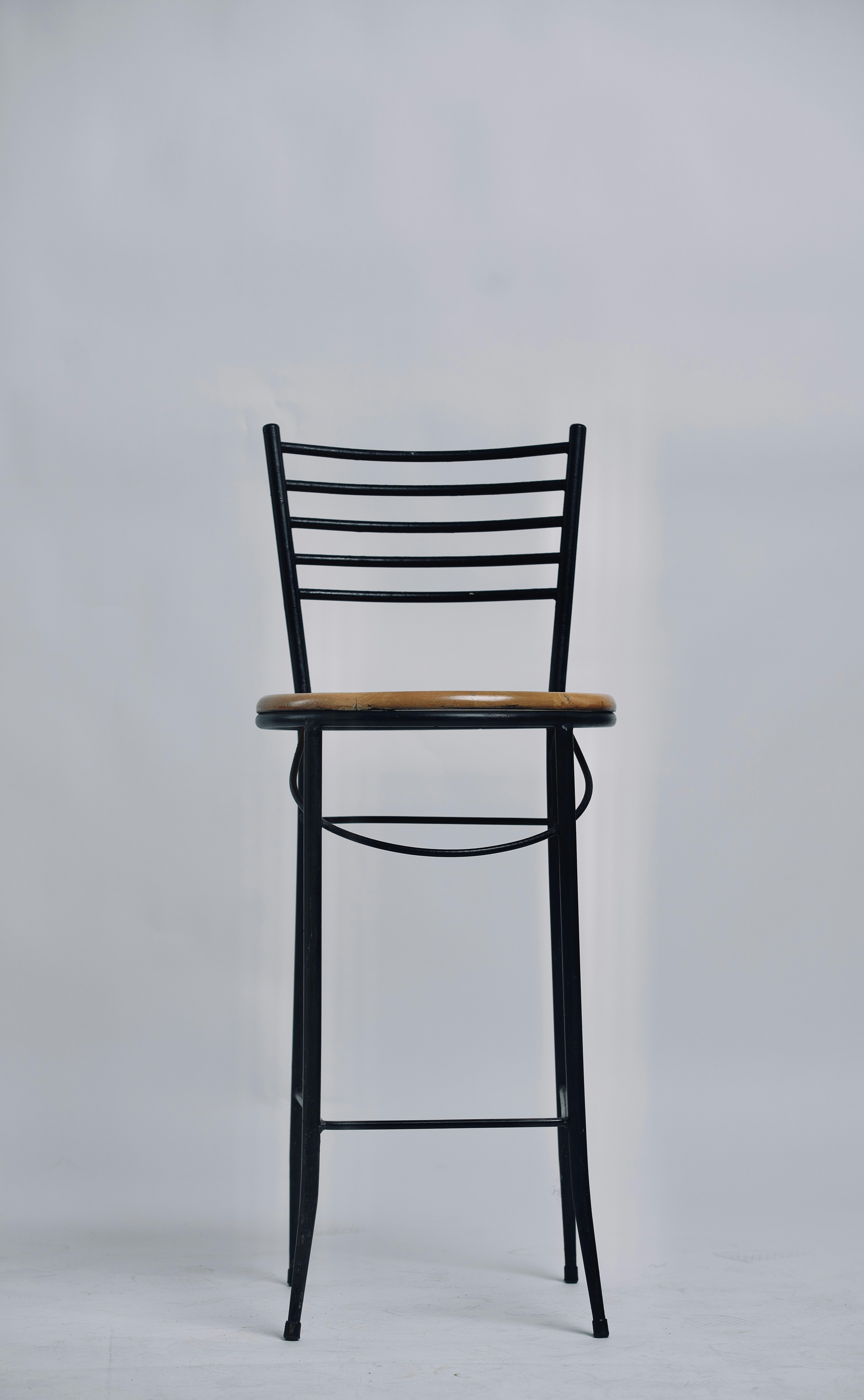 a black chair with a wooden seat on a white background