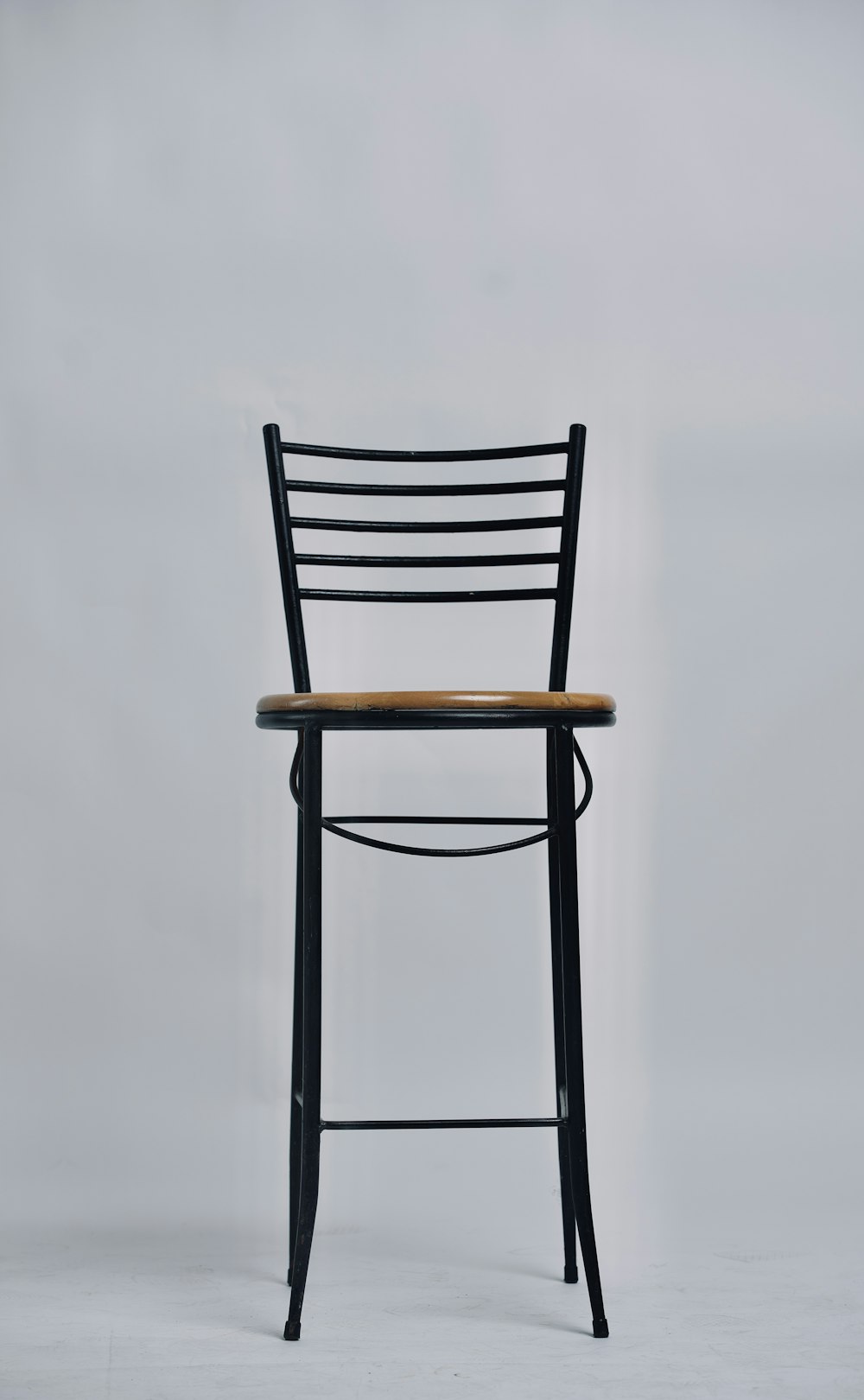 a black chair with a wooden seat on a white background